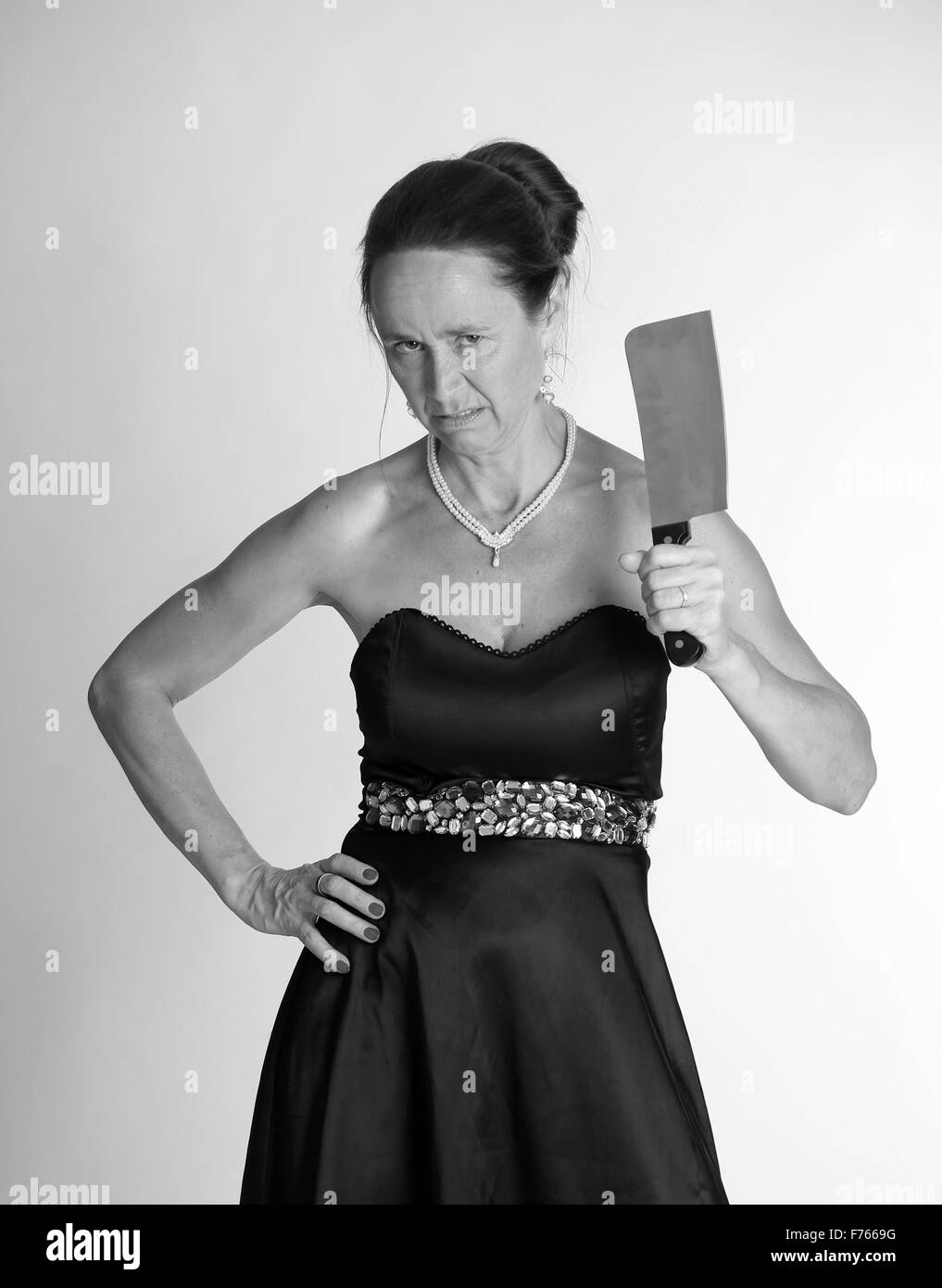 Mad mature woman with a big knife / meat cleaver Stock Photo