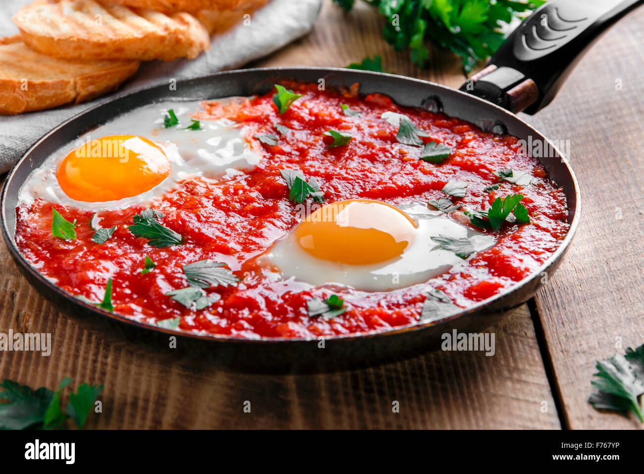 fried eggs in tomato sauce in the pan Stock Photo Alamy