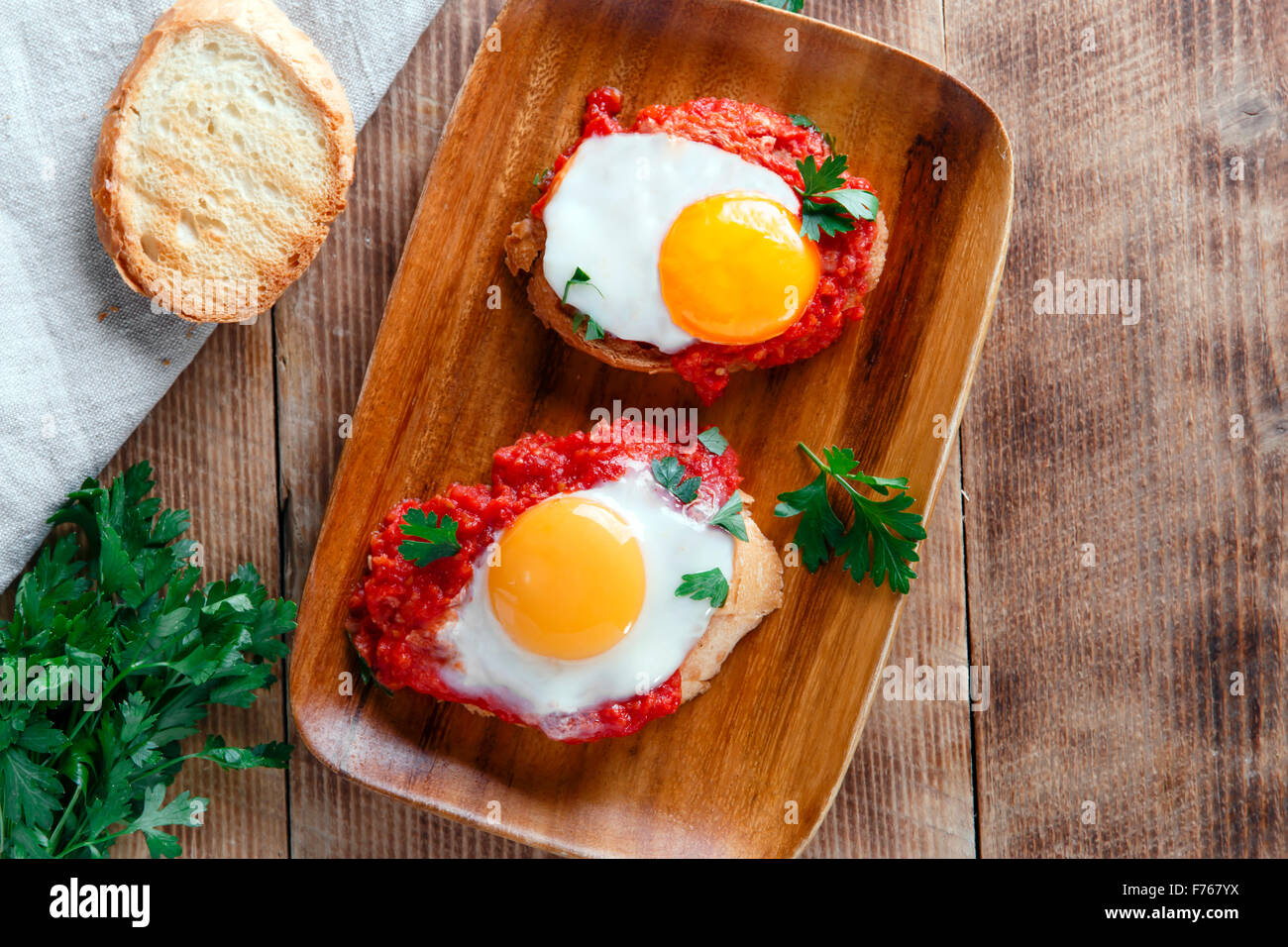 fried eggs with tomato sauce on bruschetta Stock Photo