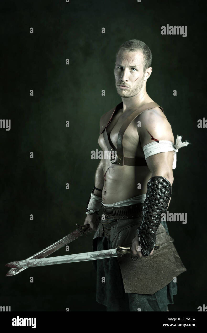 Gladiator posing isolated in a dark background Stock Photo - Alamy