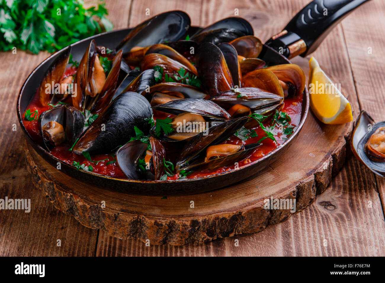 oyster mussels in red sauce in a frying pan Stock Photo Alamy