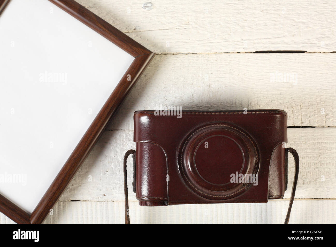 Vintage set: the old film camera and frame for photos on a wooden ...