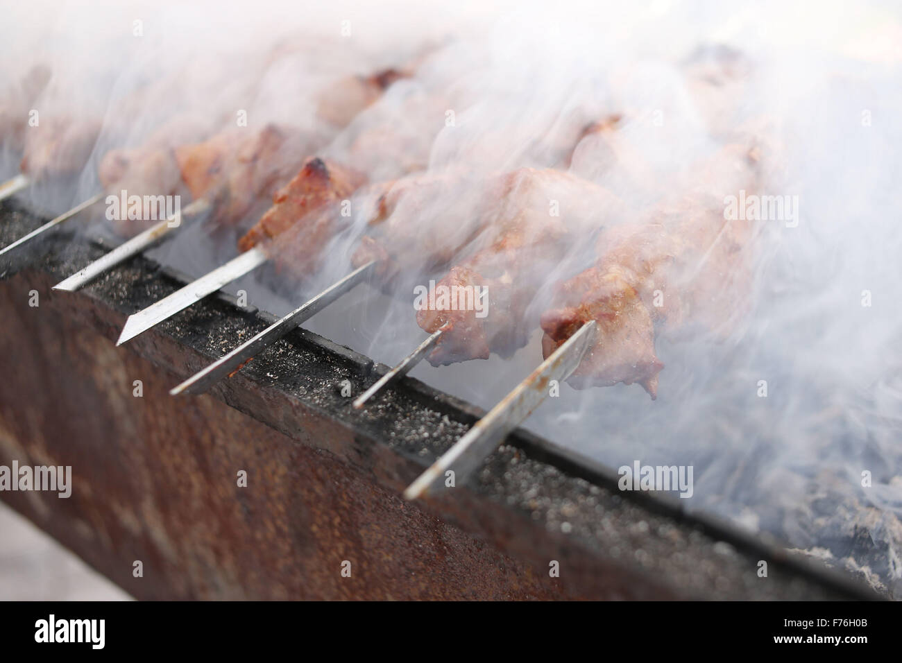 Grilling marinated shashlik on a grill. Shashlik is a form of Shish kebab  popular in Eastern, Central Europe and other places. Shashlyk meaning skewer  Stock Photo - Alamy