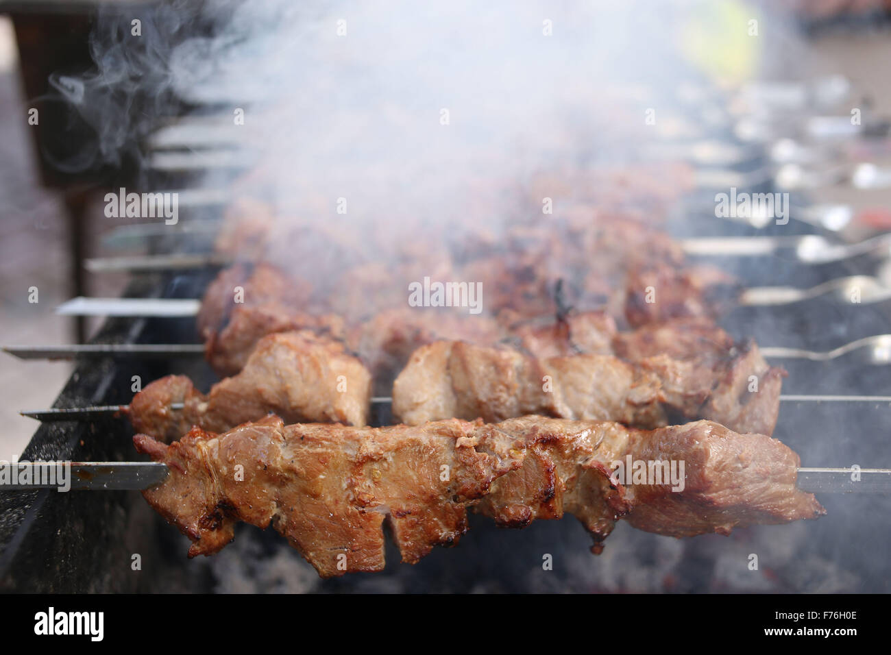 Grilling marinated shashlik on a grill. Shashlik is a form of Shish kebab  popular in Eastern, Central Europe and other places. Shashlyk meaning skewer  Stock Photo - Alamy