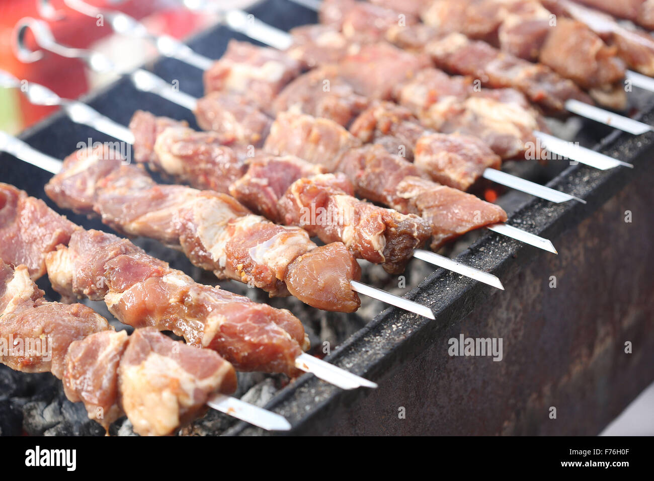 Grilling marinated shashlik on a grill. Shashlik is a form of Shish kebab  popular in Eastern, Central Europe and other places. Shashlyk meaning skewer  Stock Photo - Alamy