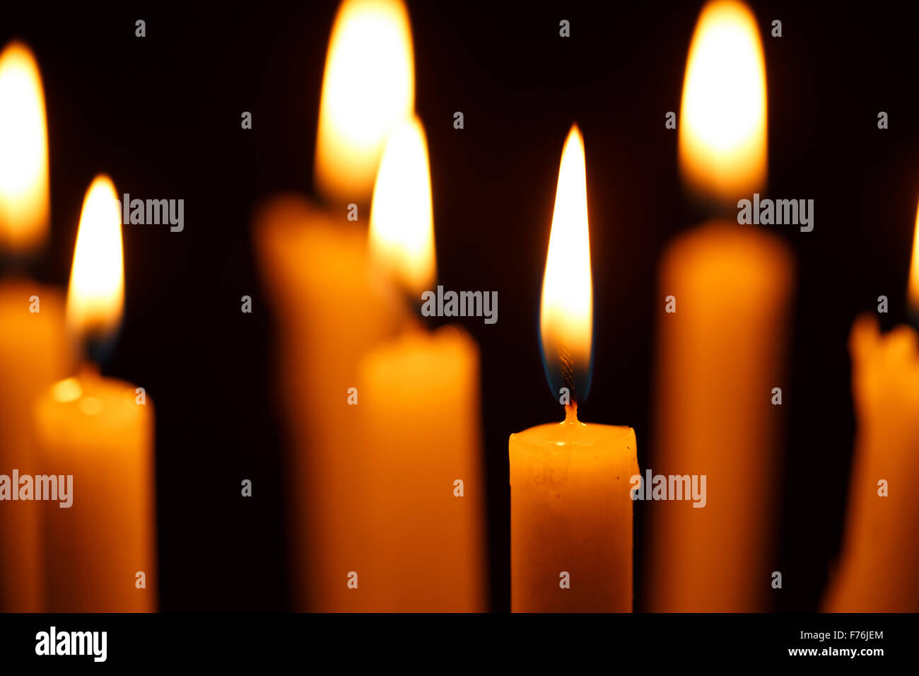 Many burning candles on black background Stock Photo - Alamy