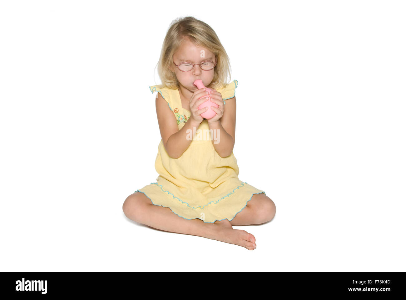 Girl with Balloon Trying Hard Stock Photo