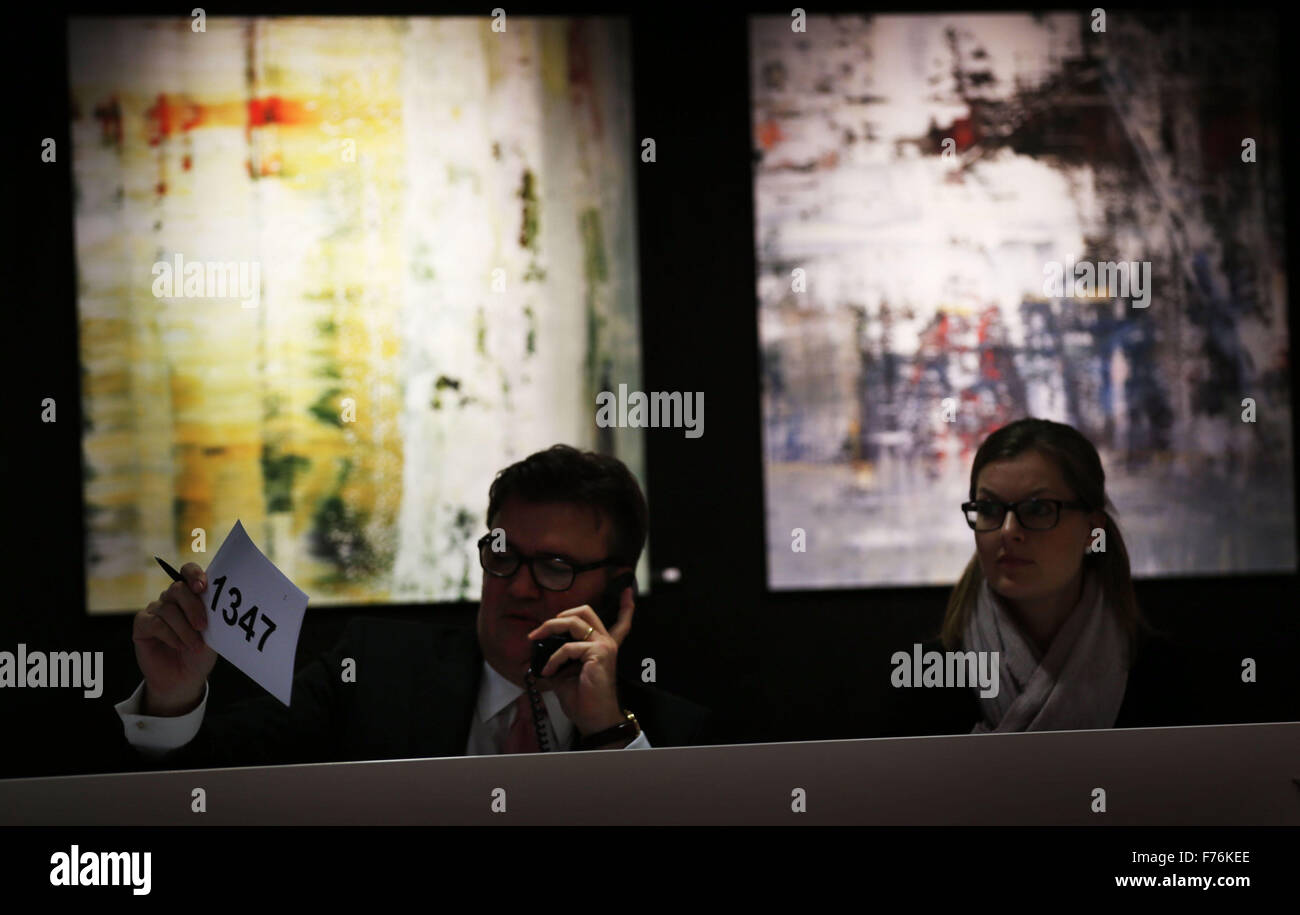 Employees at the Van Ham auction house accept bids per phone in front of paintings by the artist Gerhard Richter in Cologne, Germany, 26 November 2015. Pieces by Gerhard Richter are being auctioned in support of the Duesseldorf-based street magazine 'fiftyfifty' at the Van Ham auction house. Photo: OLIVER BERG/dpa Stock Photo
