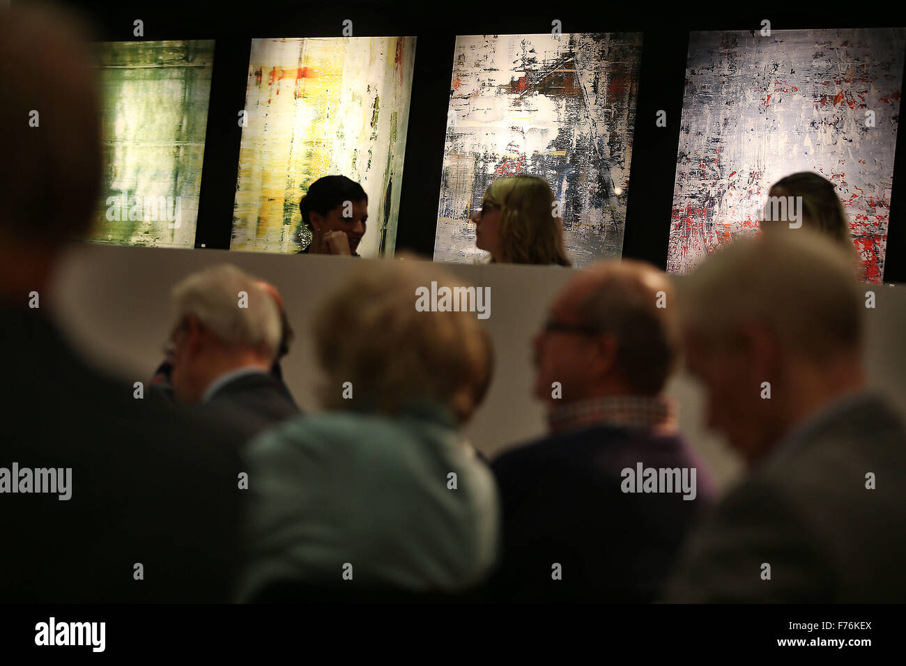 Customers follow an art auction at the Van Ham auction house in front of paintings by the artist Gerhard Richter in Cologne, Germany, 26 November 2015. Pieces by Gerhard Richter are being auctioned in support of the Duesseldorf-based street magazine 'fiftyfifty' at the Van Ham auction house. Photo: OLIVER BERG/dpa Stock Photo