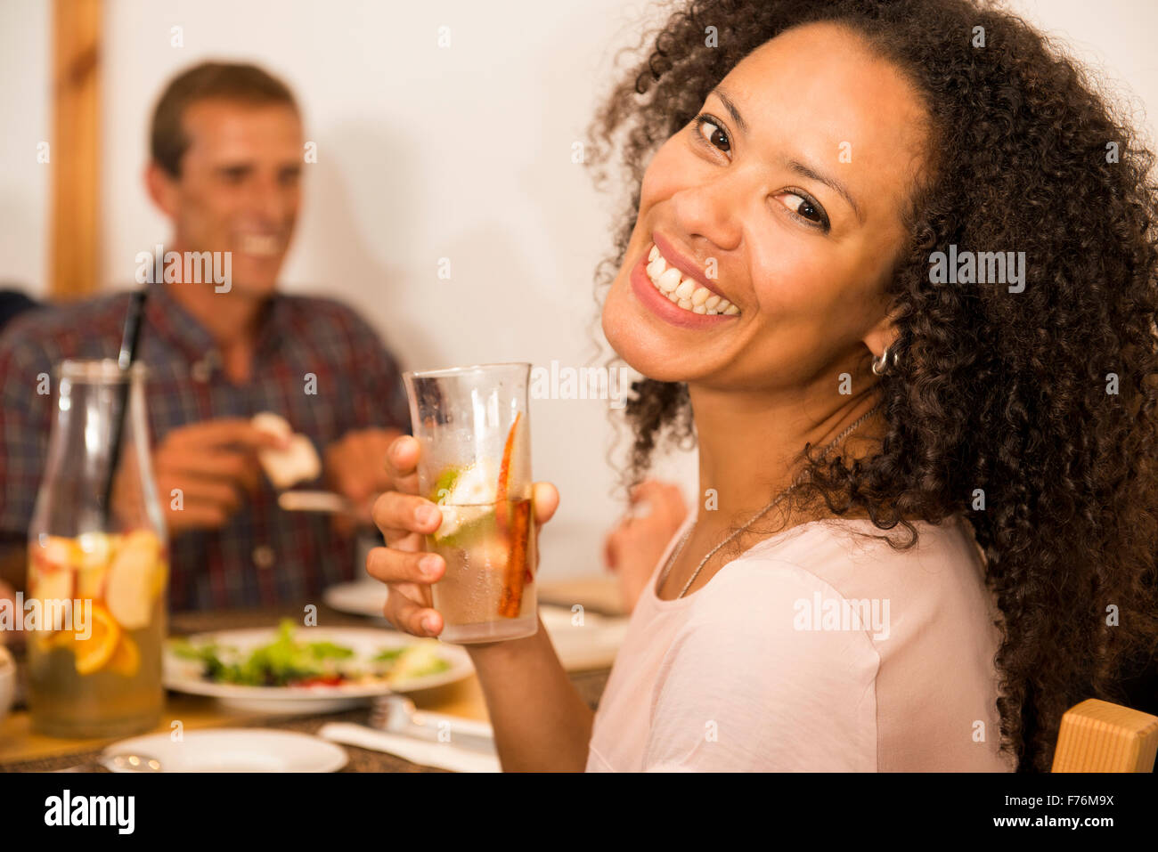 Happy Afro-American woman at the restaurant having a drink Stock Photo