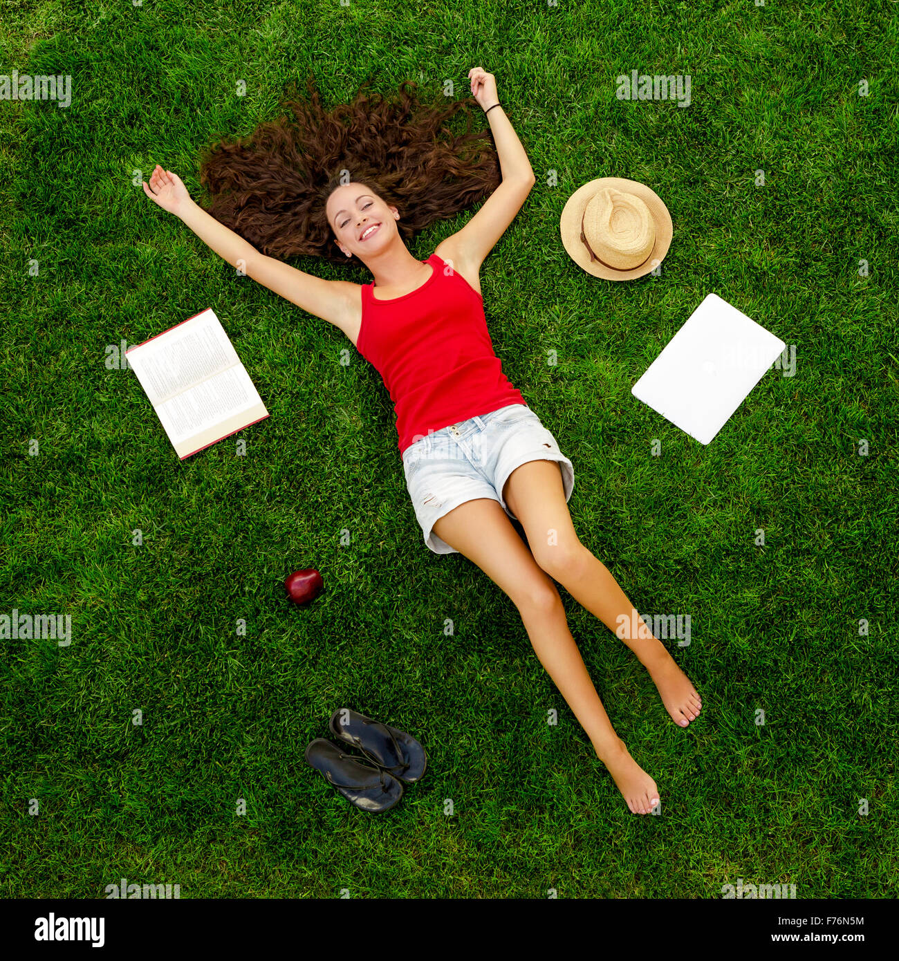 Happy young woman lying on grass Stock Photo - Alamy