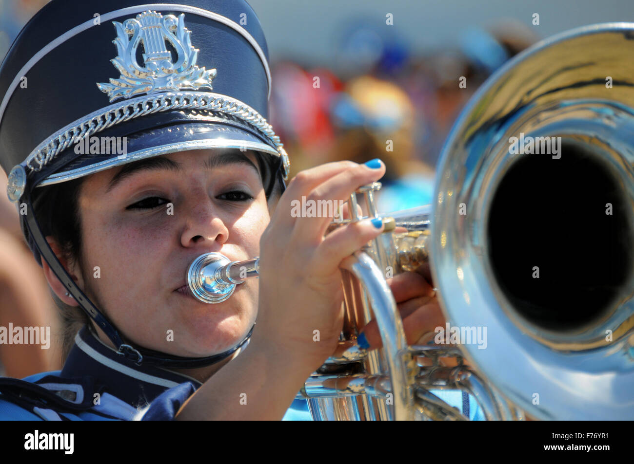 Young woman in band marching on holiday in full uniform with horn Stock Photo