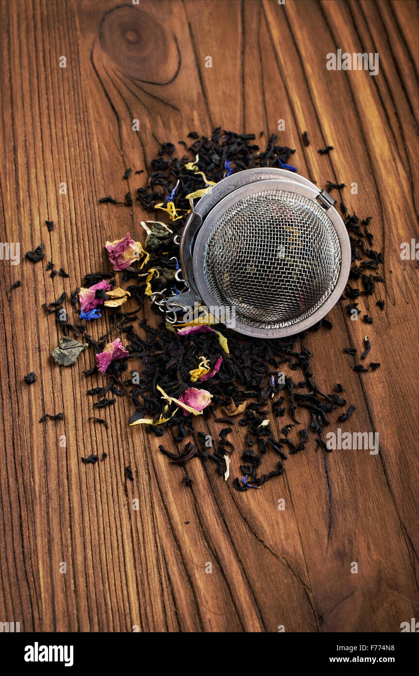 Herbal tea and tea strainer on wooden Stock Photo