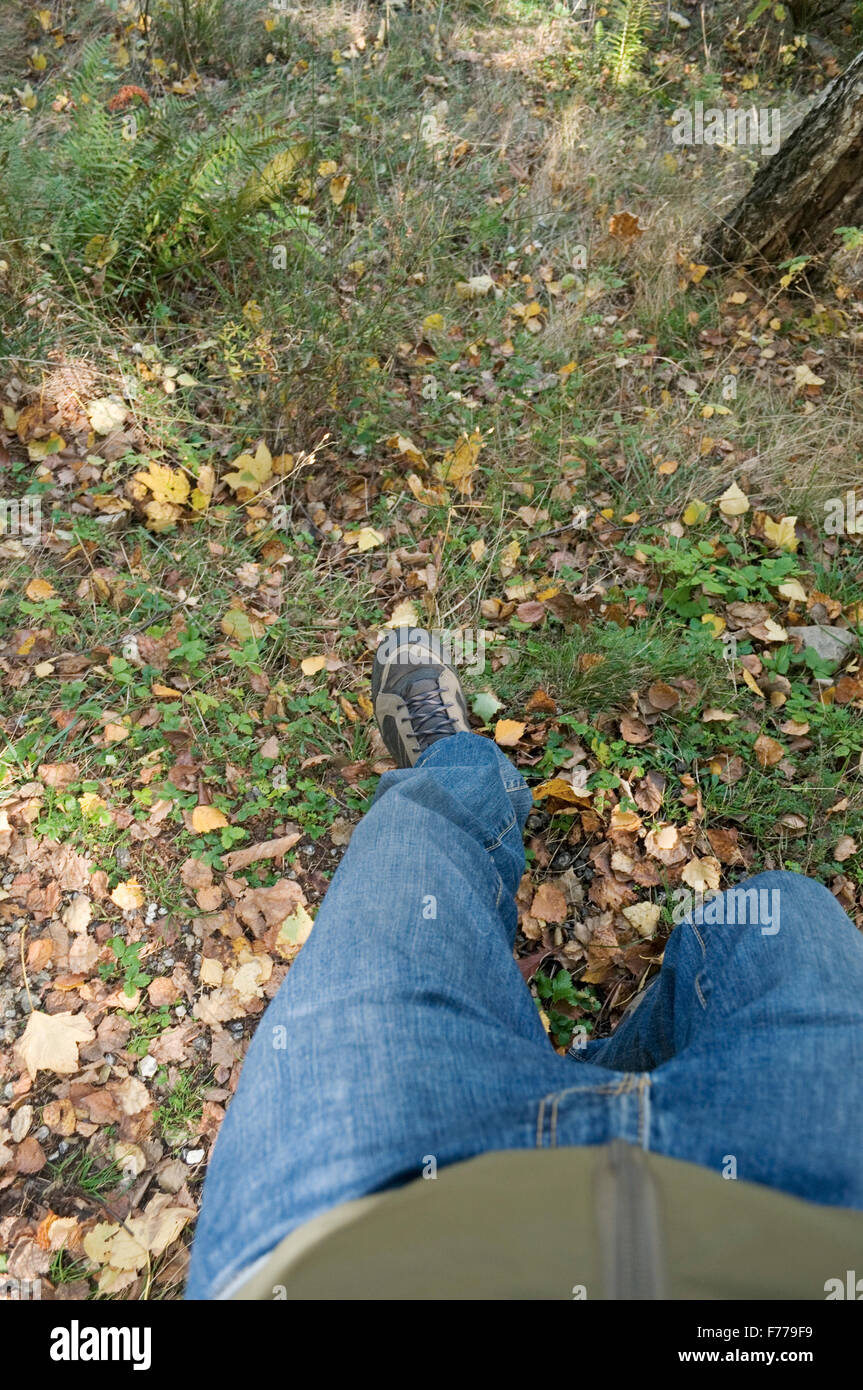 Hiker sliding down a slope Stock Photo