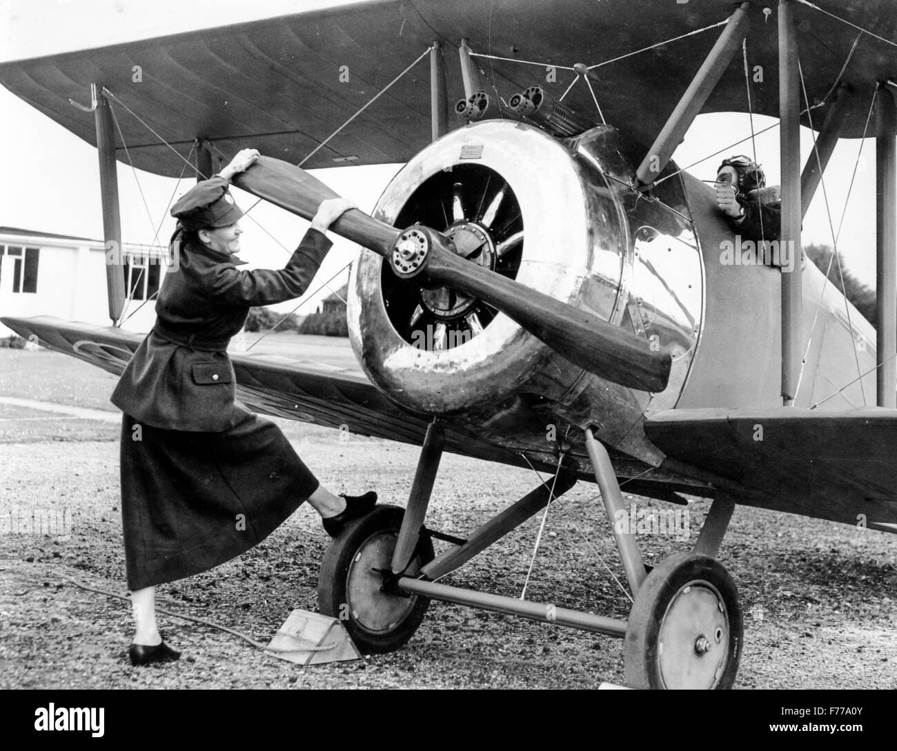 a woman in military uniform 20 years' starts the engine of an airplane,1962 Stock Photo