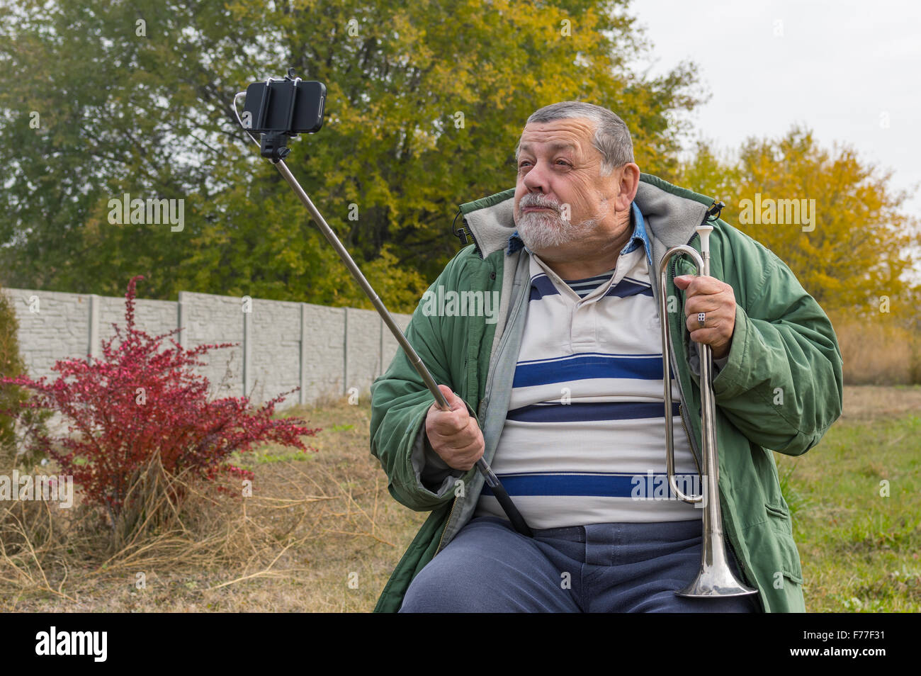 Ridiculous senior man making faces while doing selfie outdoor Stock Photo