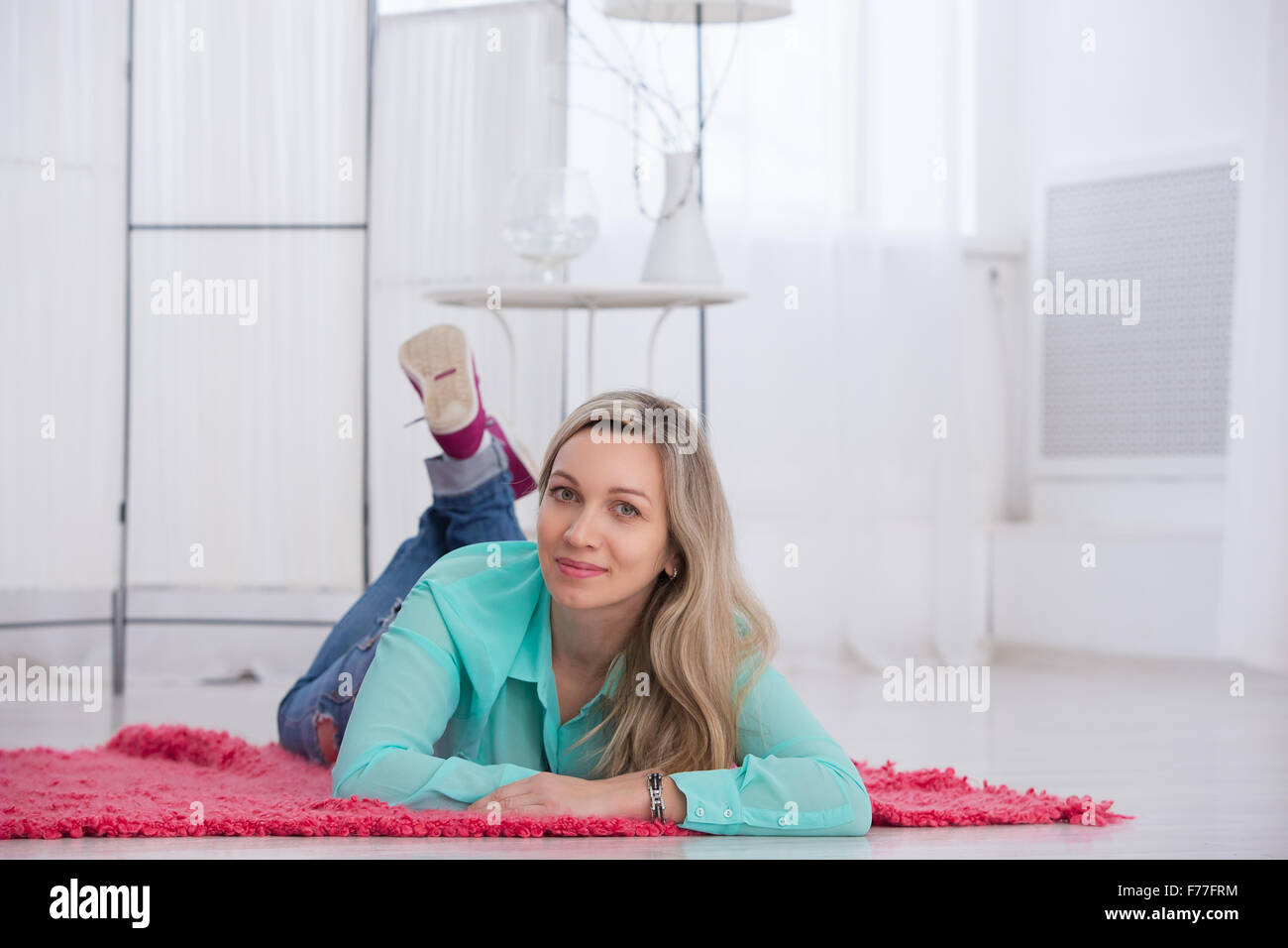beautiful girl lying on the floor and smiling in a light room Stock ...