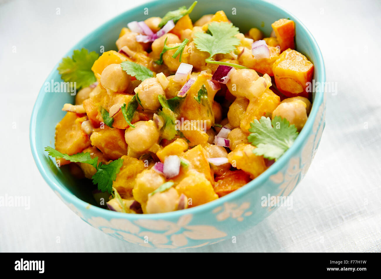 Warm pumpkin and chickpea salad with a tahini dressing in a bowl. Stock Photo
