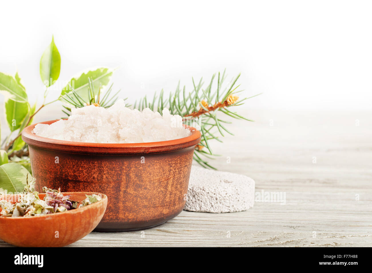 Aromatic bath salt and dried herbs on a wooden surface Stock Photo
