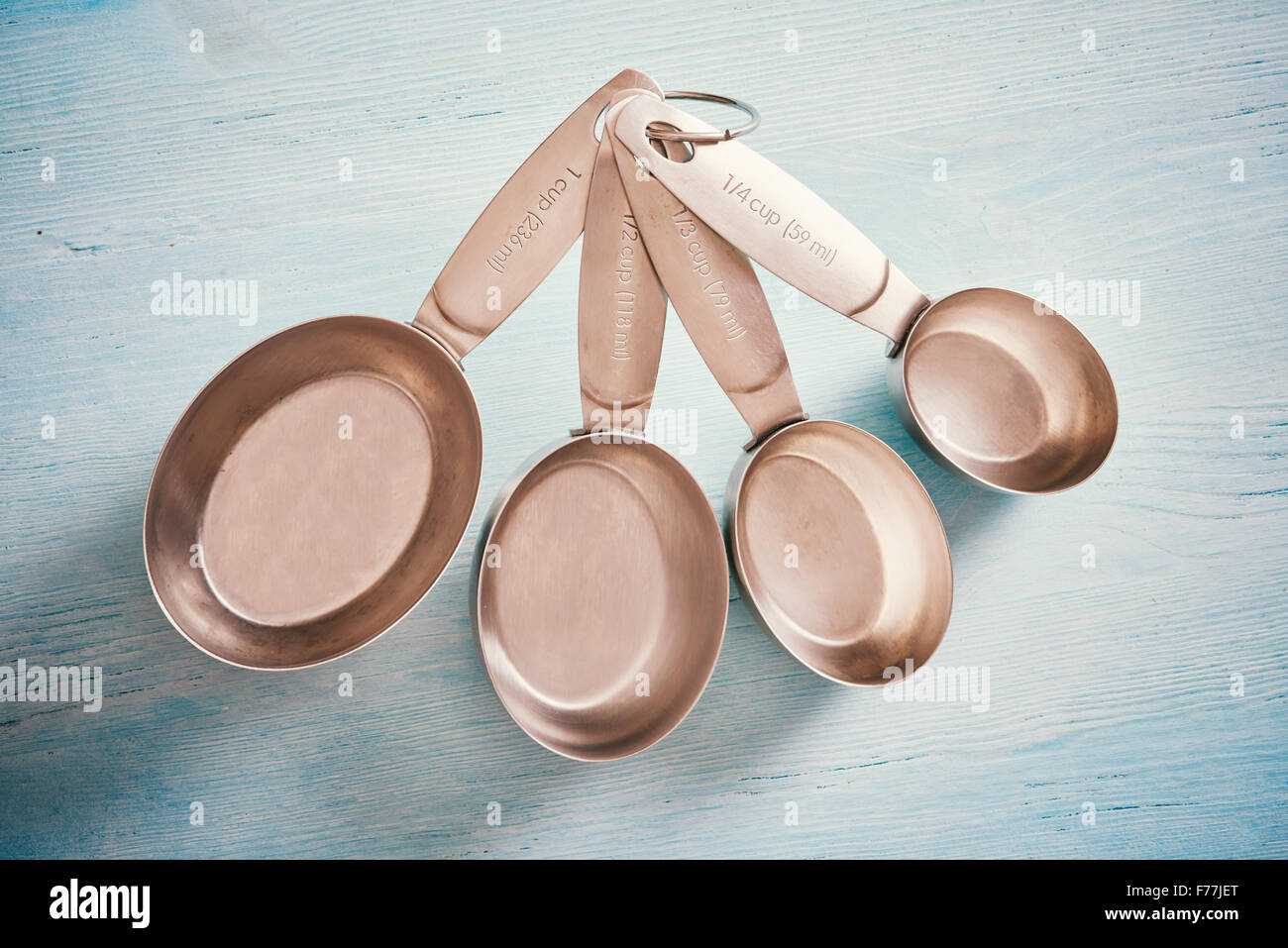 https://c8.alamy.com/comp/F77JET/measuring-spoons-cups-on-blue-wooden-table-F77JET.jpg