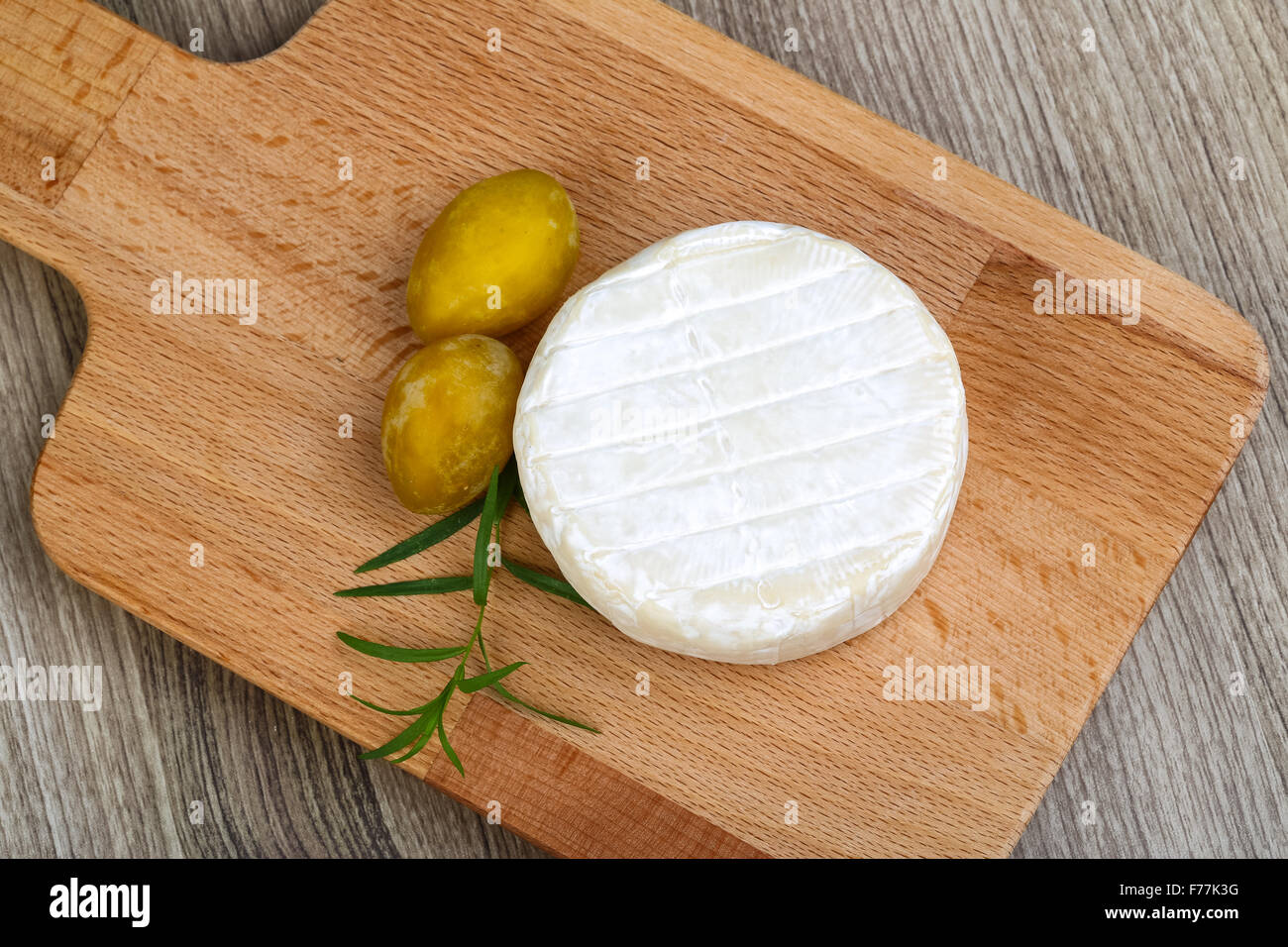 Round Brie cheese with yellow plums and estragon Stock Photo Alamy