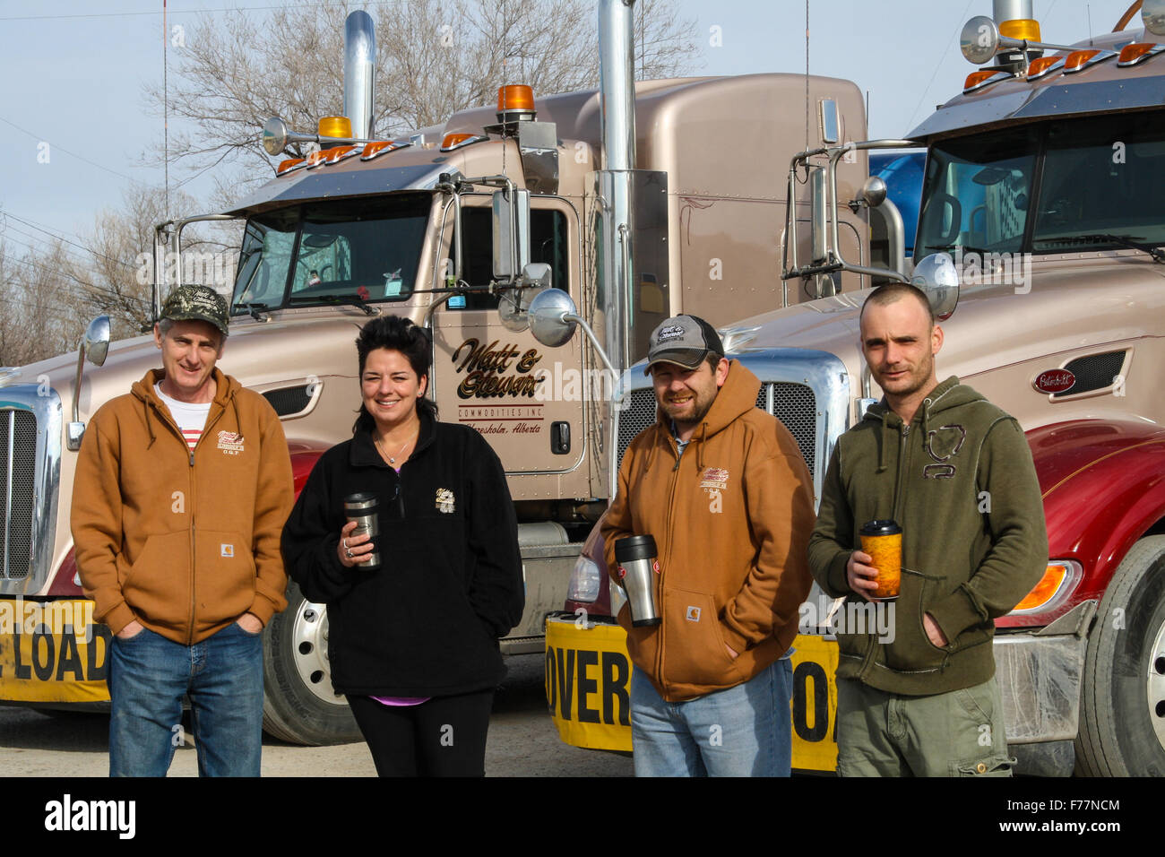 Foreign truck drivers pose beside their 'Watt and Stewart' Canadian company peterbilt trucks in