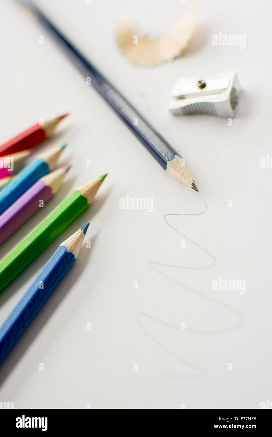 Pencils laid out on white paper ready for creative craft drawing, sketching and colouring Stock