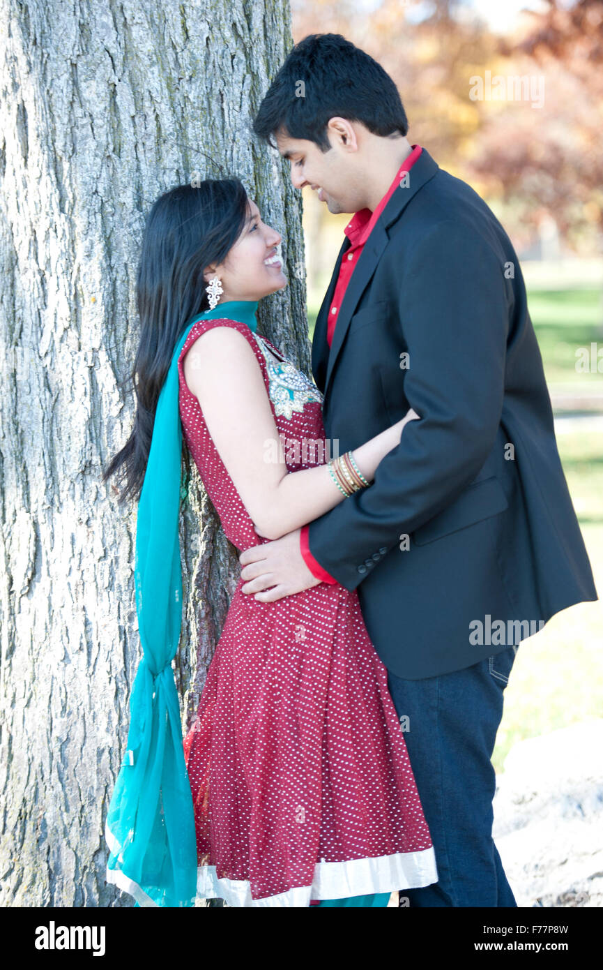 A young and happy Indian couple looking at each other in the fall near ...