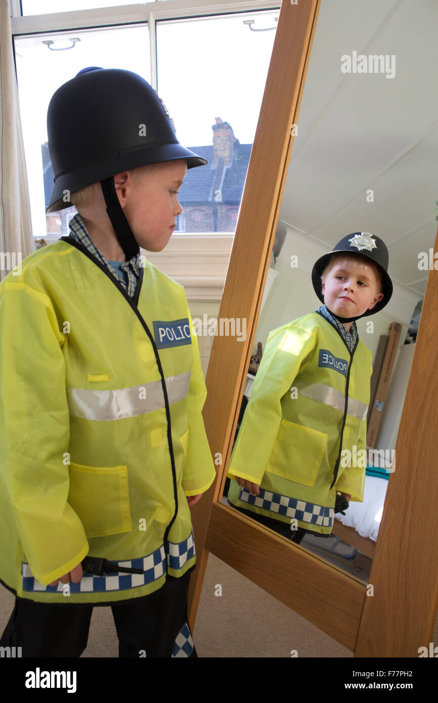 Boy (aged 4) wearing his British 'Bobby' Police Officer costume in front of  the mirror at home in his London terraced house, UK Stock Photo - Alamy