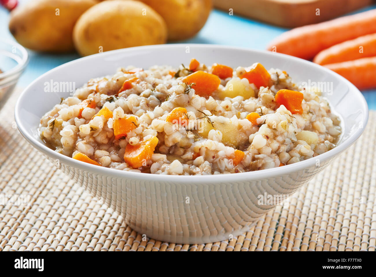 Buckwheat soup in white bowl on wooden blue table - gluten free food Stock Photo