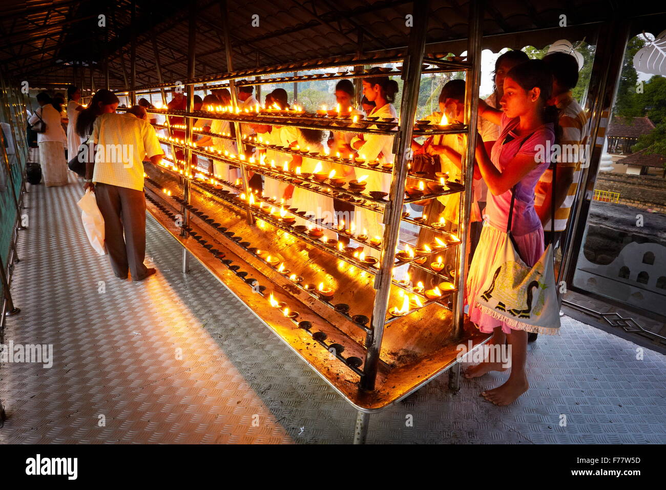 Sri Lanka, Kandy - pilgrims light up candles in the Temple of the Tooth, Sri Dalada Maligawa, Buddhist shrine, UNESCO Stock Photo