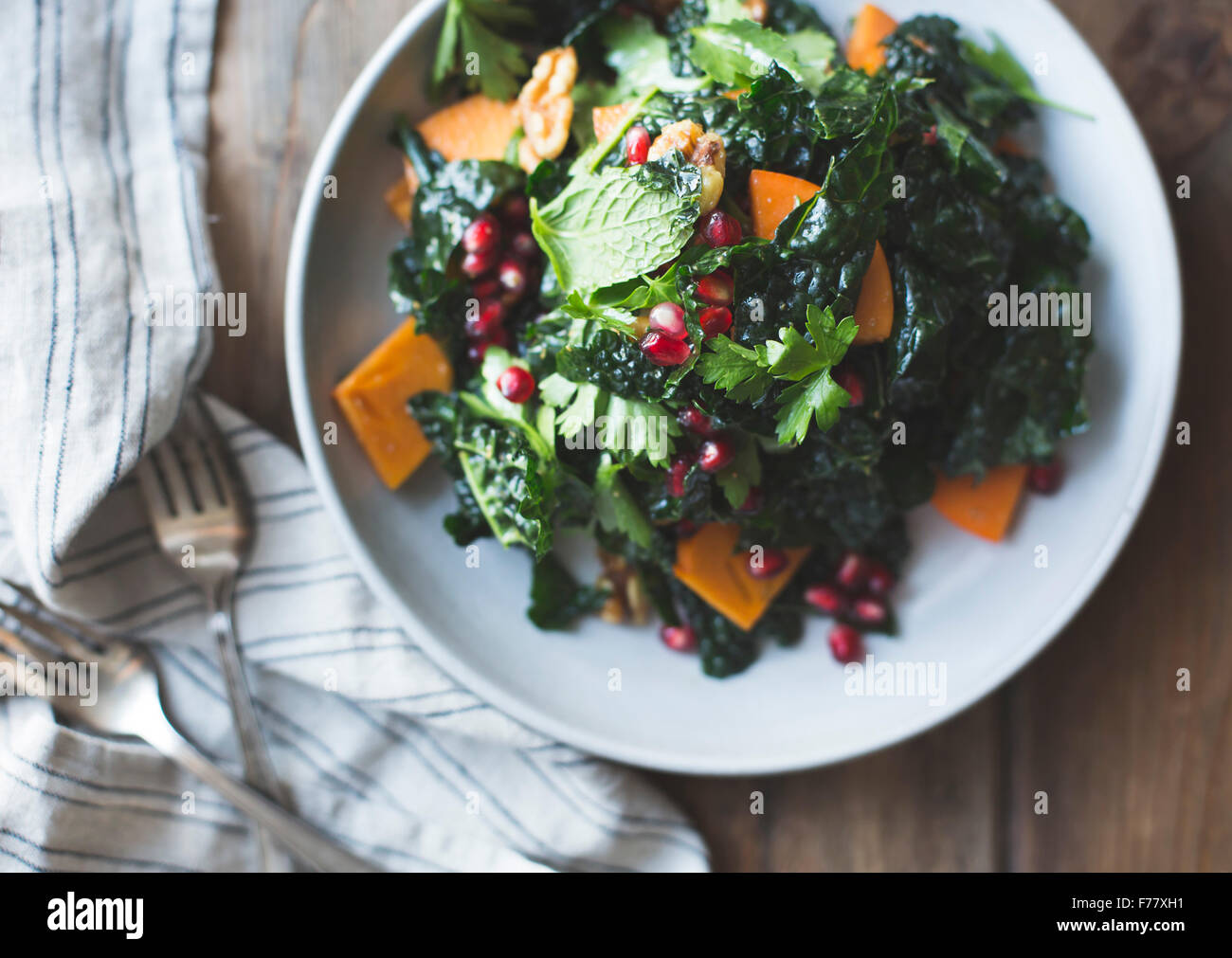 kale salad with herbs, pomegranate, persimmon Stock Photo