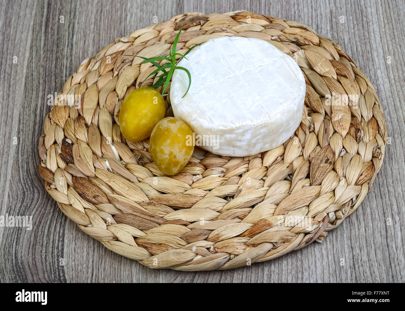 Brie cheese with yellow plums and estragon leaves Stock Photo Alamy