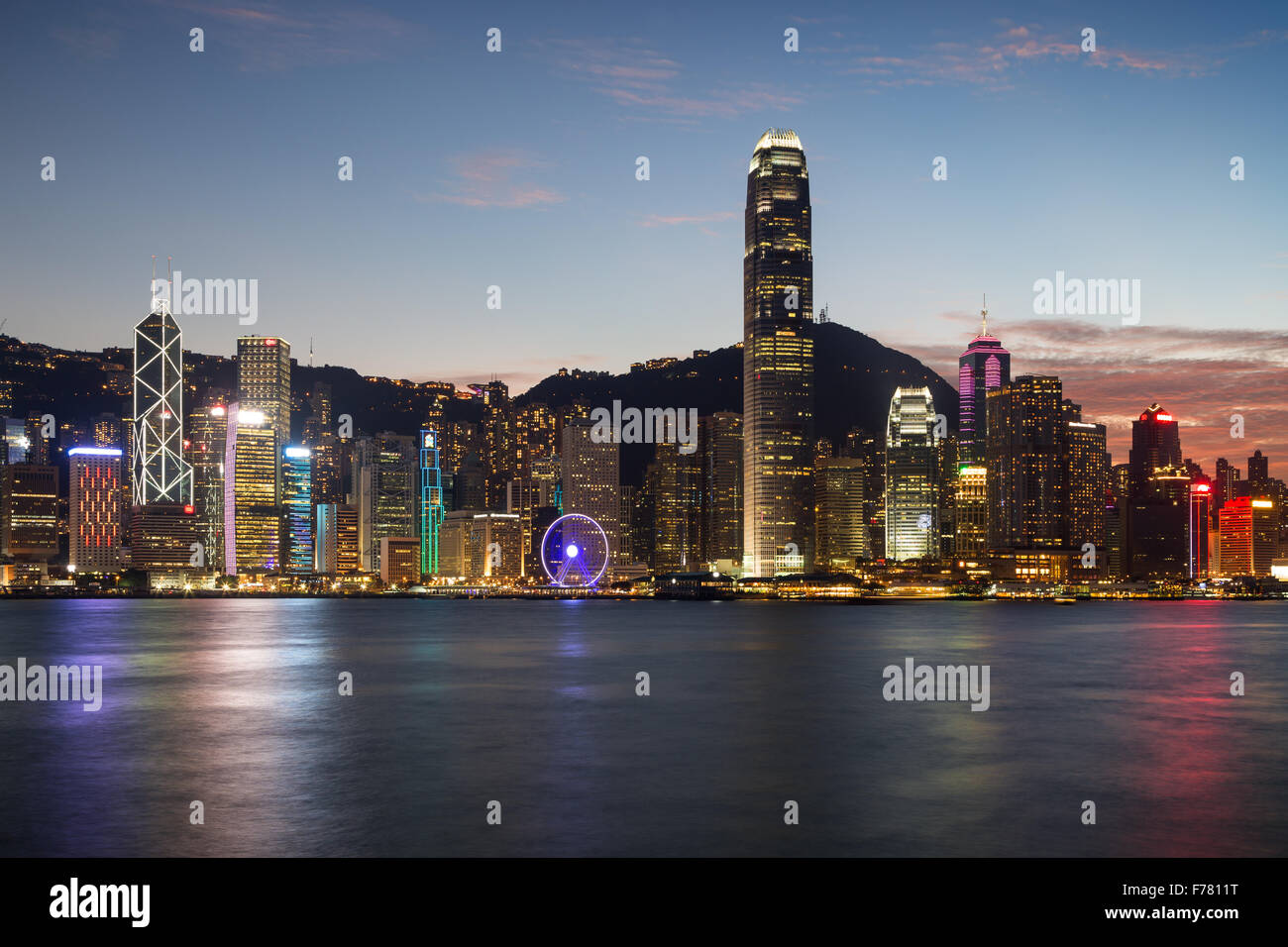 Scenic view of Hong Kong Island's skyline at evening over Victoria Harbor with lit urban skyscrapers in Hong Kong, China. Stock Photo
