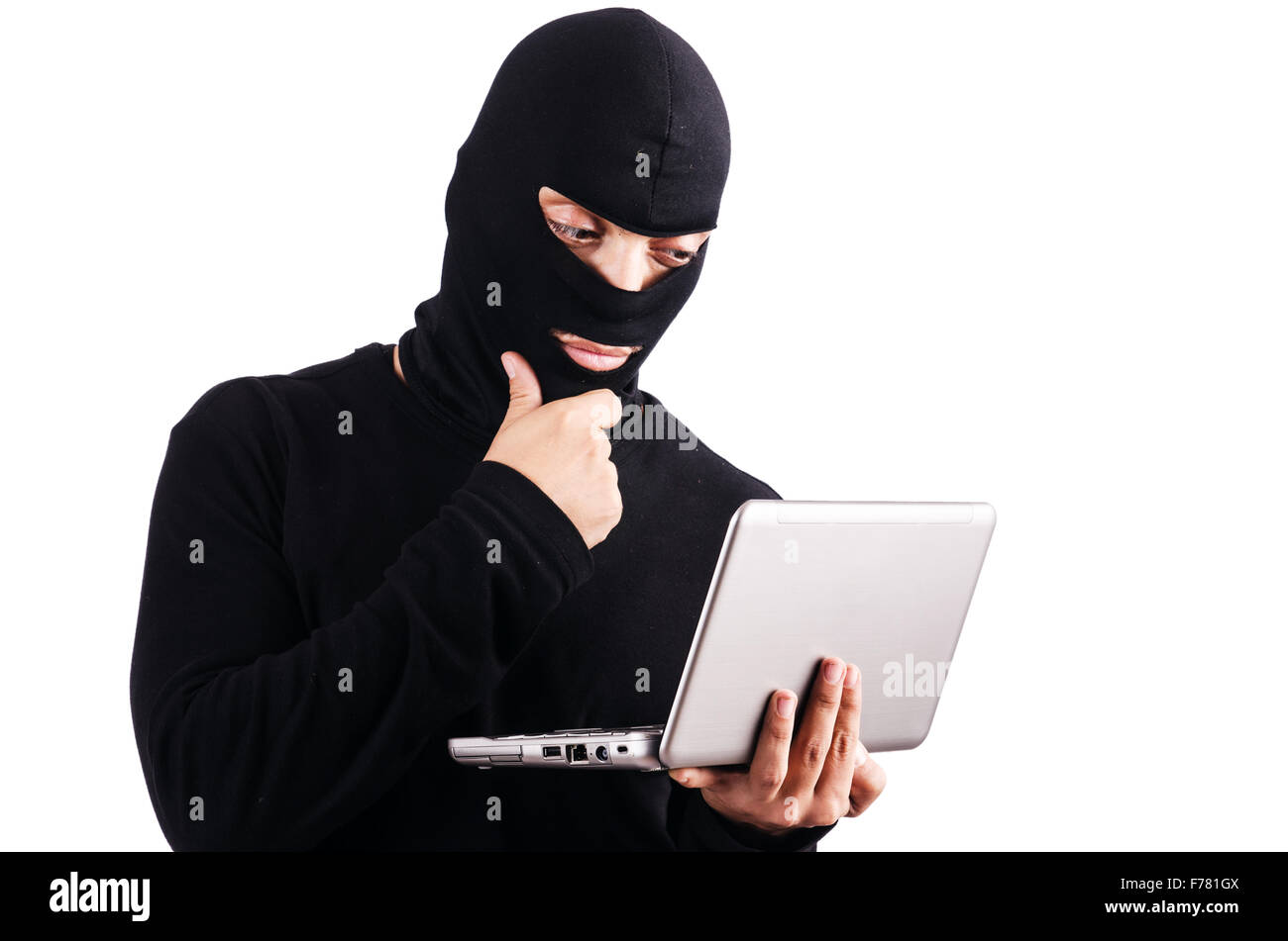 Hacker with computer wearing balaclava Stock Photo - Alamy