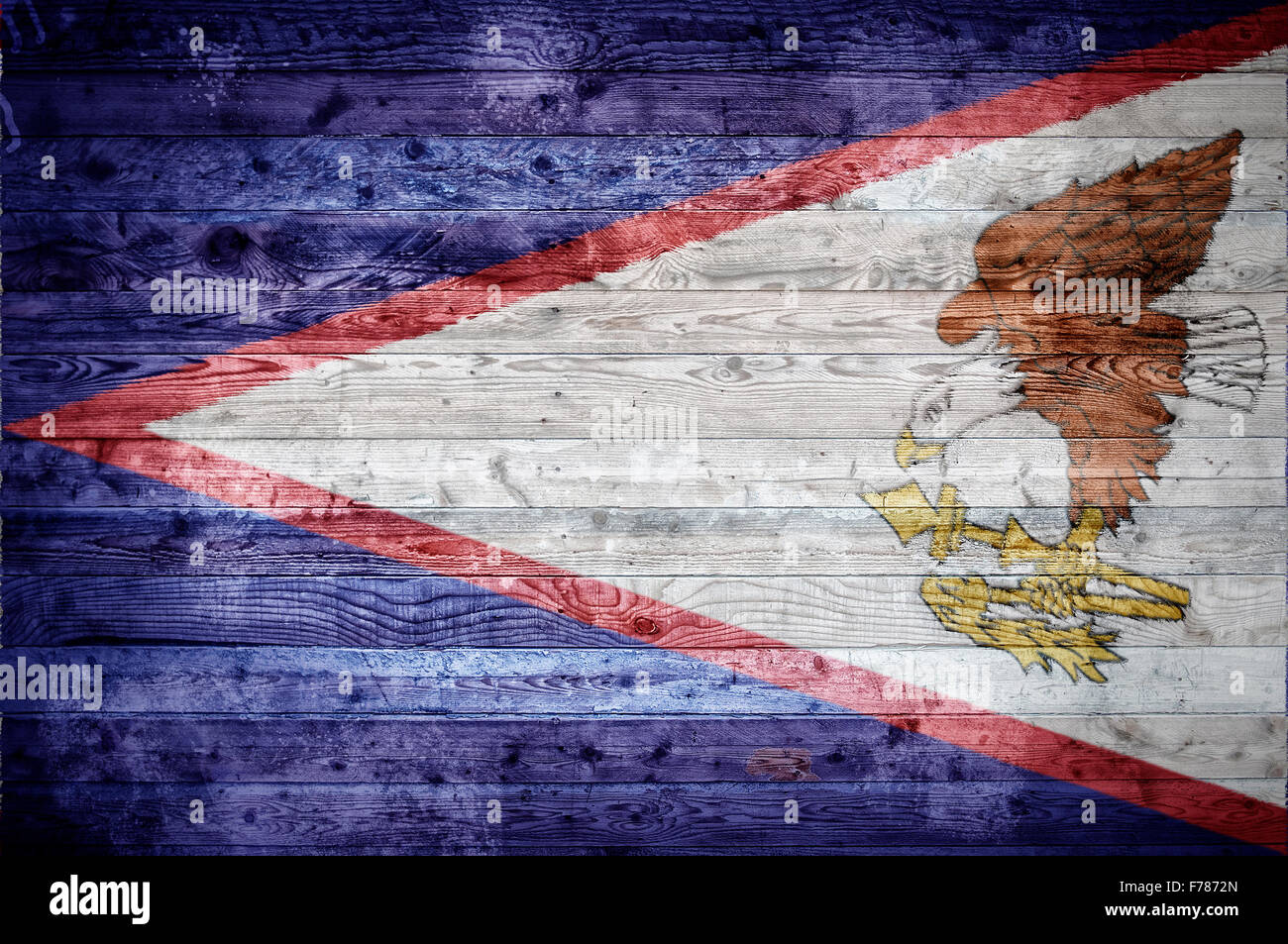 A vignetted background image of the flag of American Samoa painted onto wooden boards of a wall or floor. Stock Photo