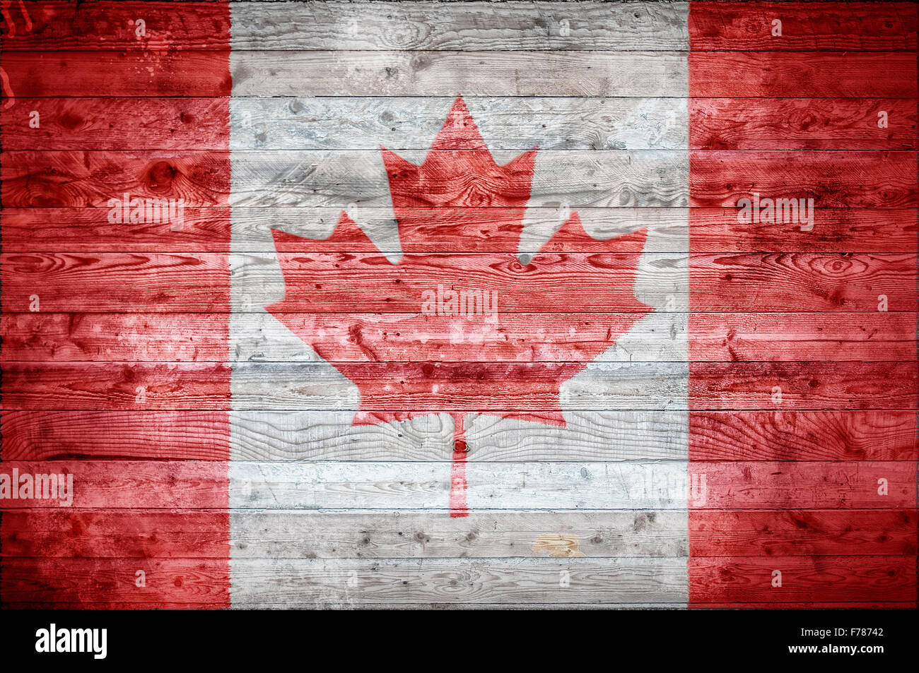 A vignetted background image of the flag of Canada painted onto wooden boards of a wall or floor. Stock Photo