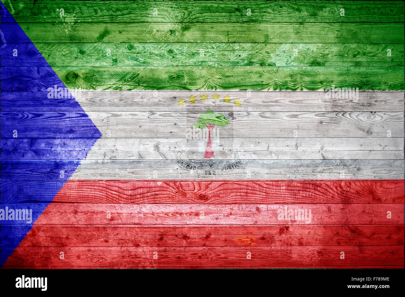 A vignetted background image of the flag of Equatorial Guinea painted onto wooden boards of a wall or floor. Stock Photo