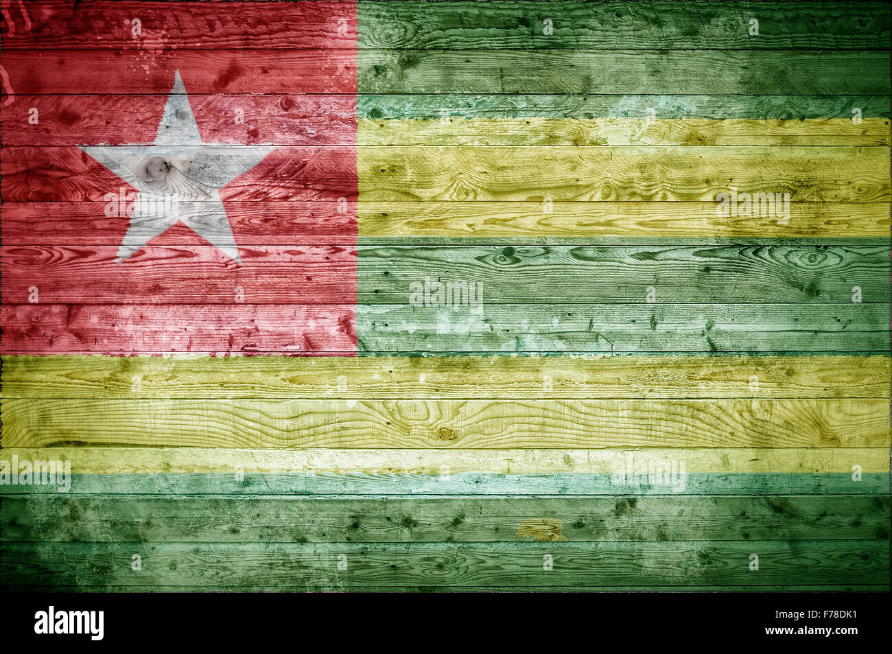 A vignetted background image of the flag of Togo onto wooden boards of a wall or floor. Stock Photo