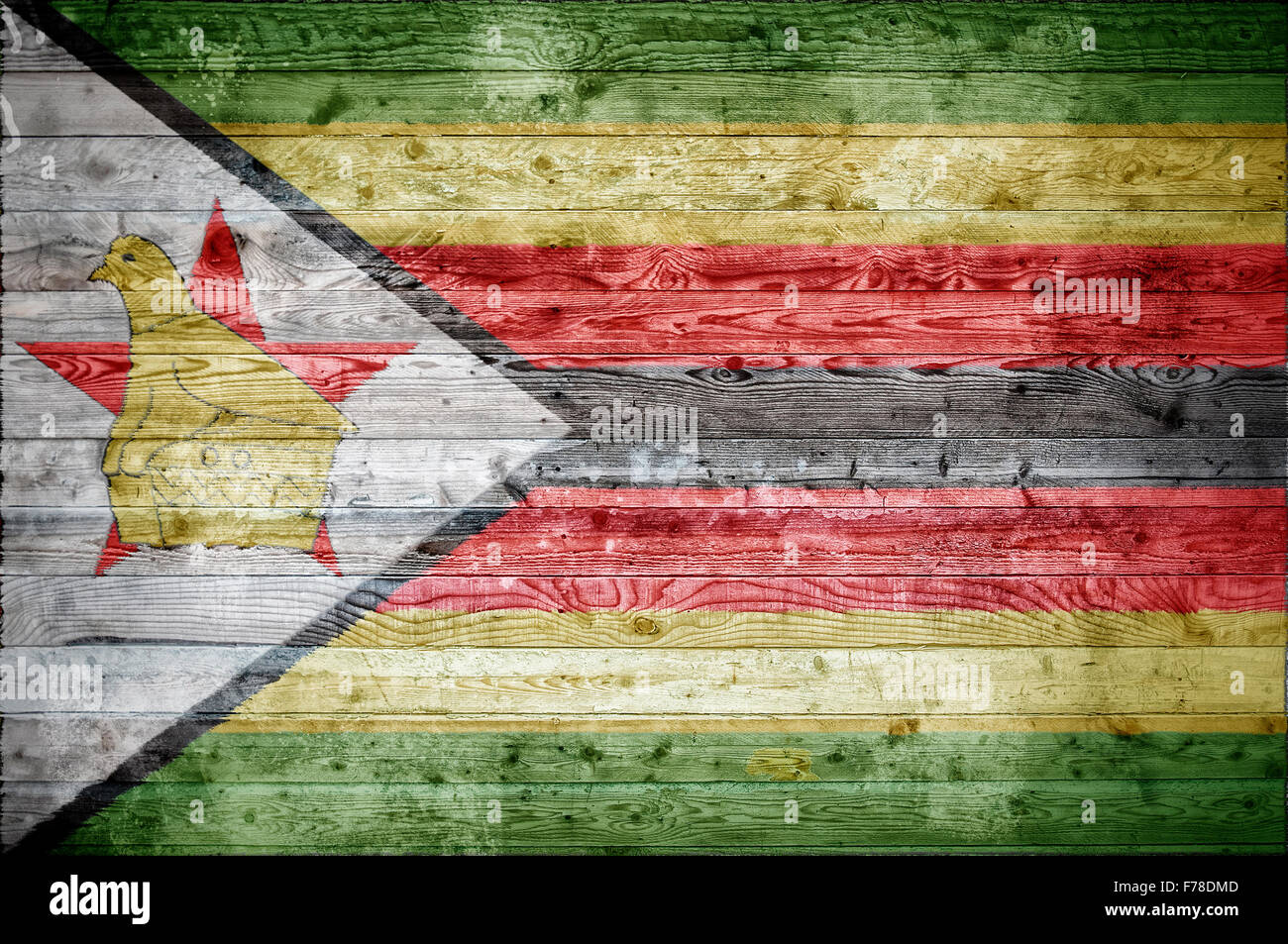 A vignetted background image of the flag of Zimbabwe onto wooden boards of a wall or floor. Stock Photo