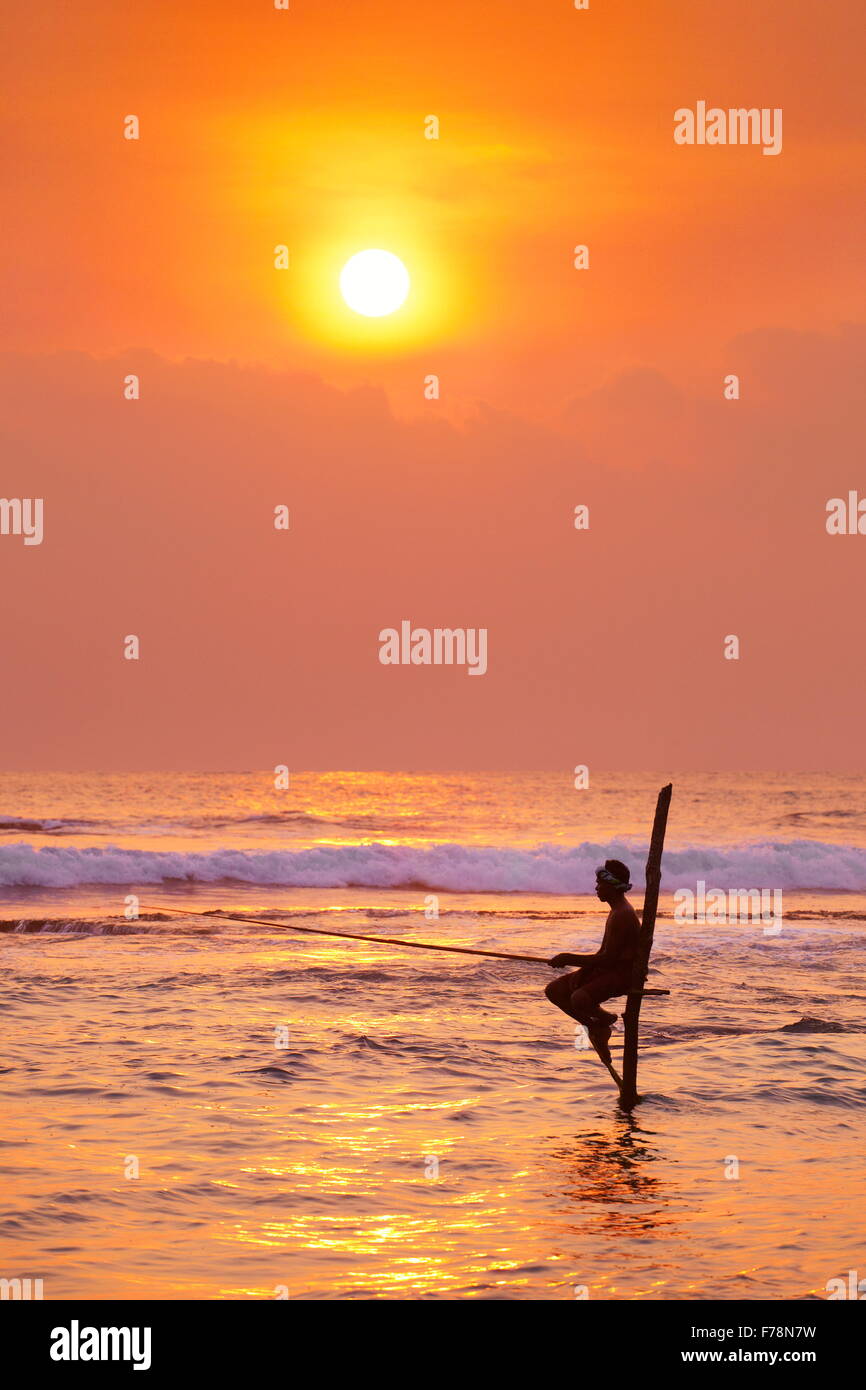 Sri Lanka - stilt fisherman at sunset time, tropical Koggala Beach, Asia Stock Photo