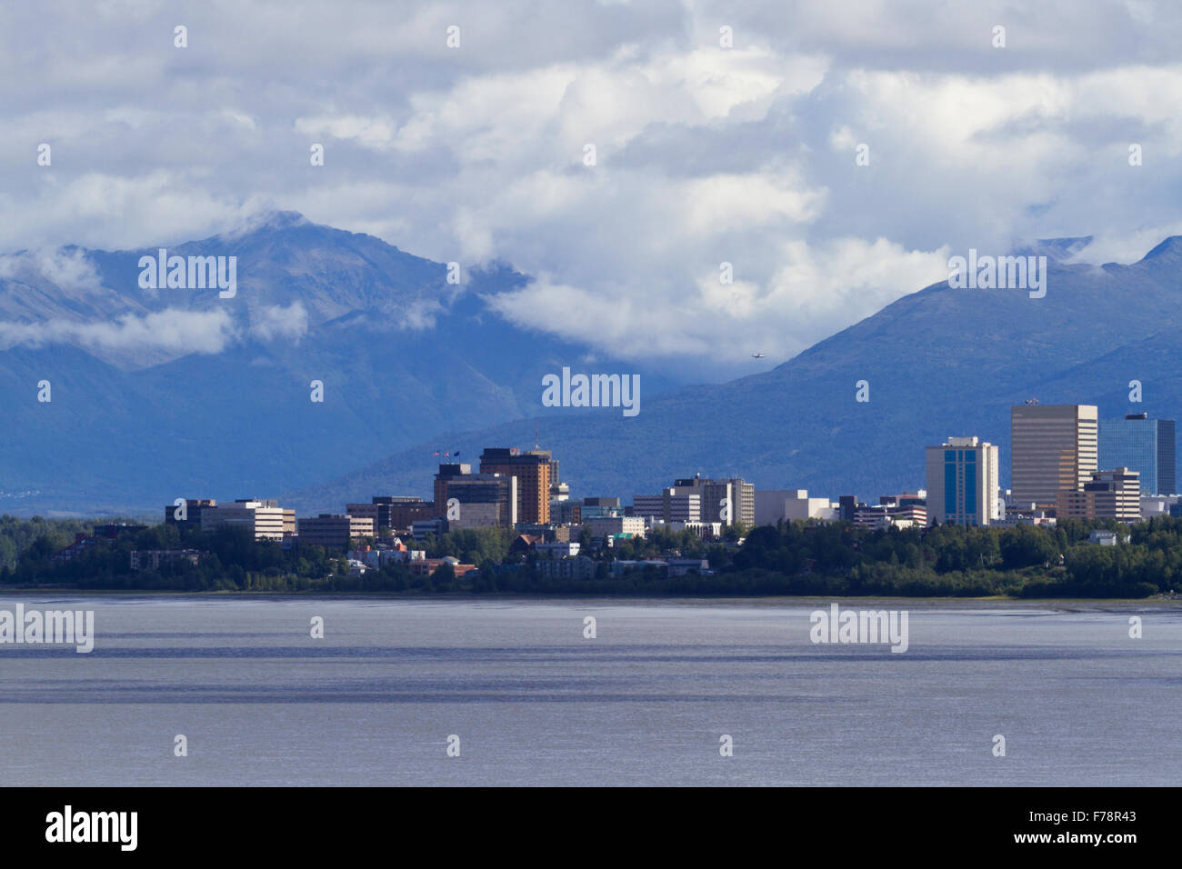 Beautiful view of Anchorage skyline across Cook Inlet with rugged Chugach Mountains behind.  Building signs and logos removed. Stock Photo