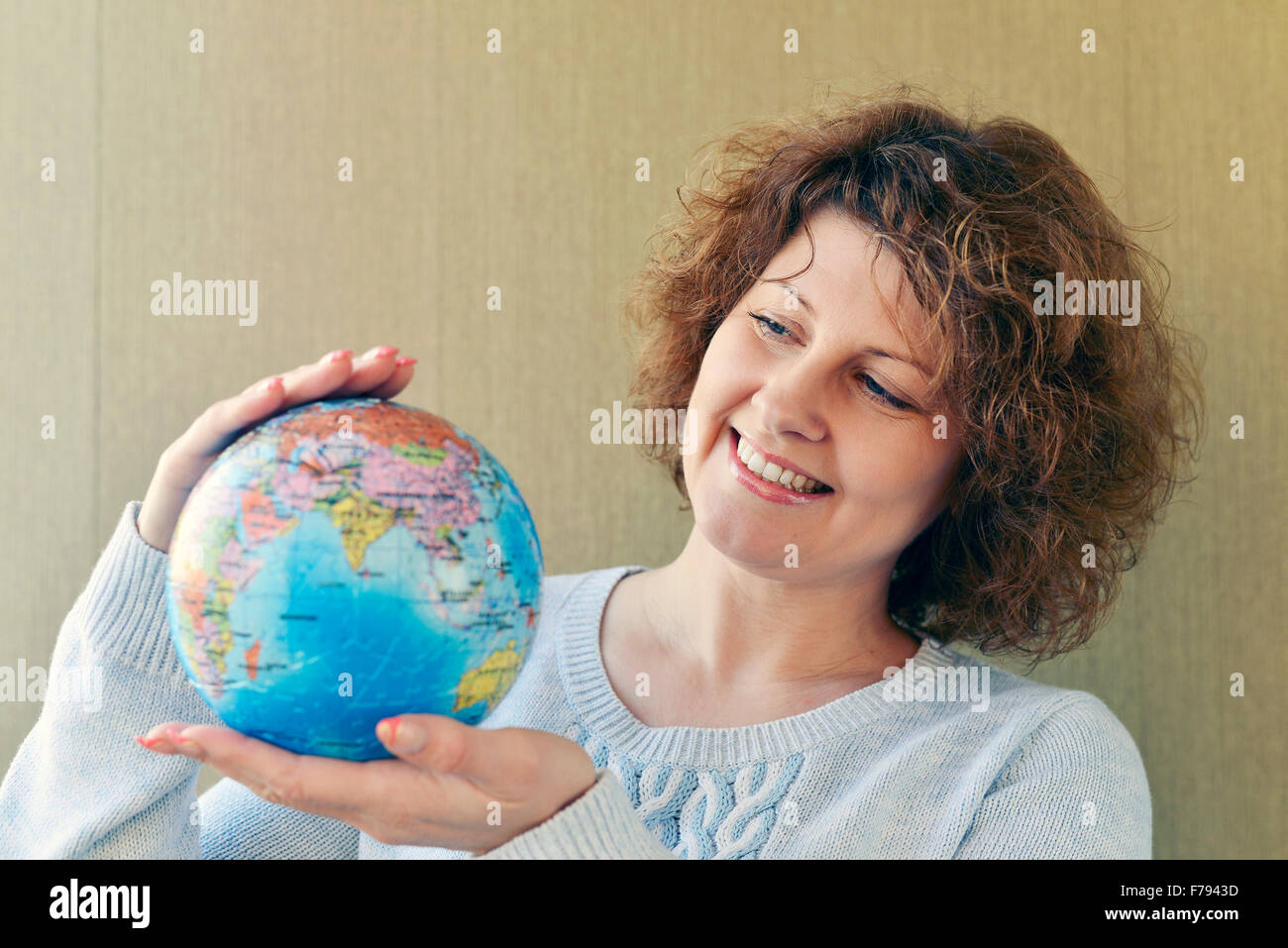 Woman with globe in hands thinking about traveling Stock Photo