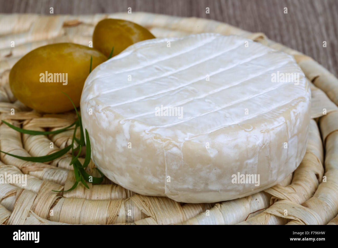 Round Brie cheese with yellow plums and estragon Stock Photo Alamy