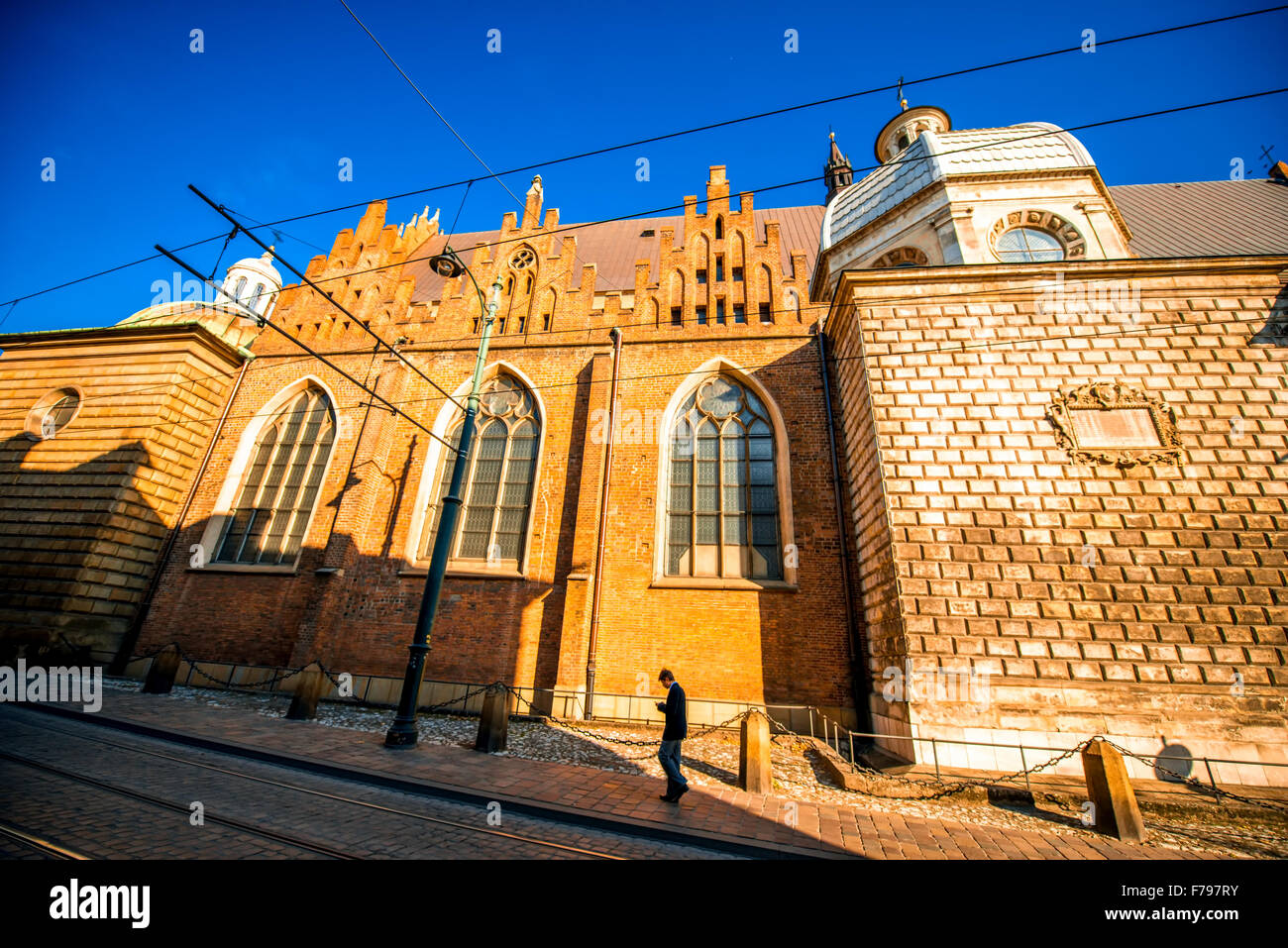 Krakow, POLAND - OCT 09, 2015: Man walking the street near St. Andrews church in old city center on the sunny morning Stock Photo