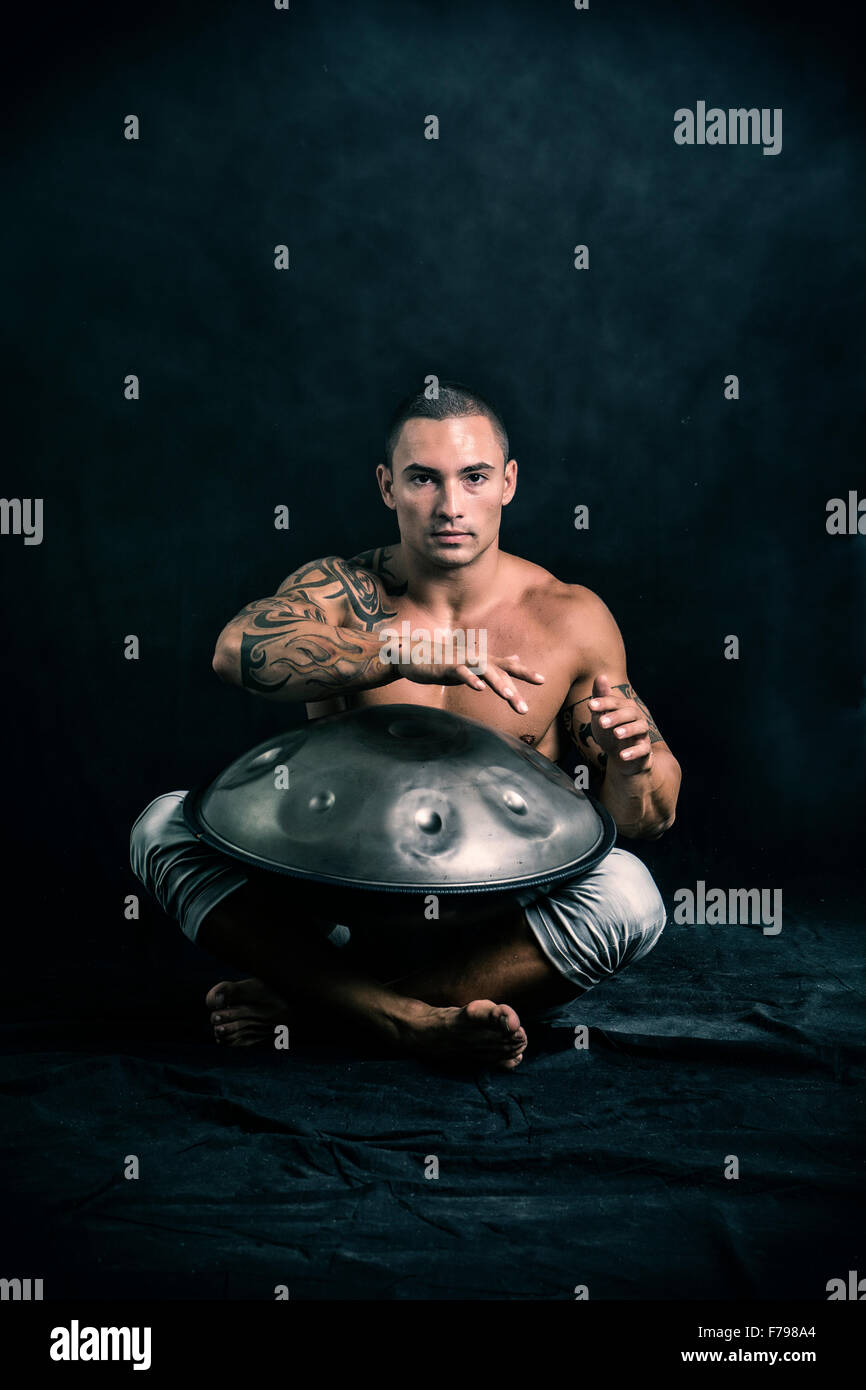 Exotic Male Drummer Drumming with Hands on Steel Pan Drums, While