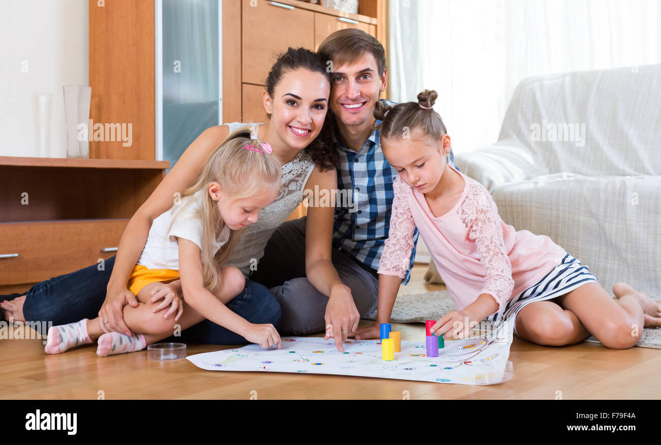 Family of four playing at board game indoor Stock Photo Alamy