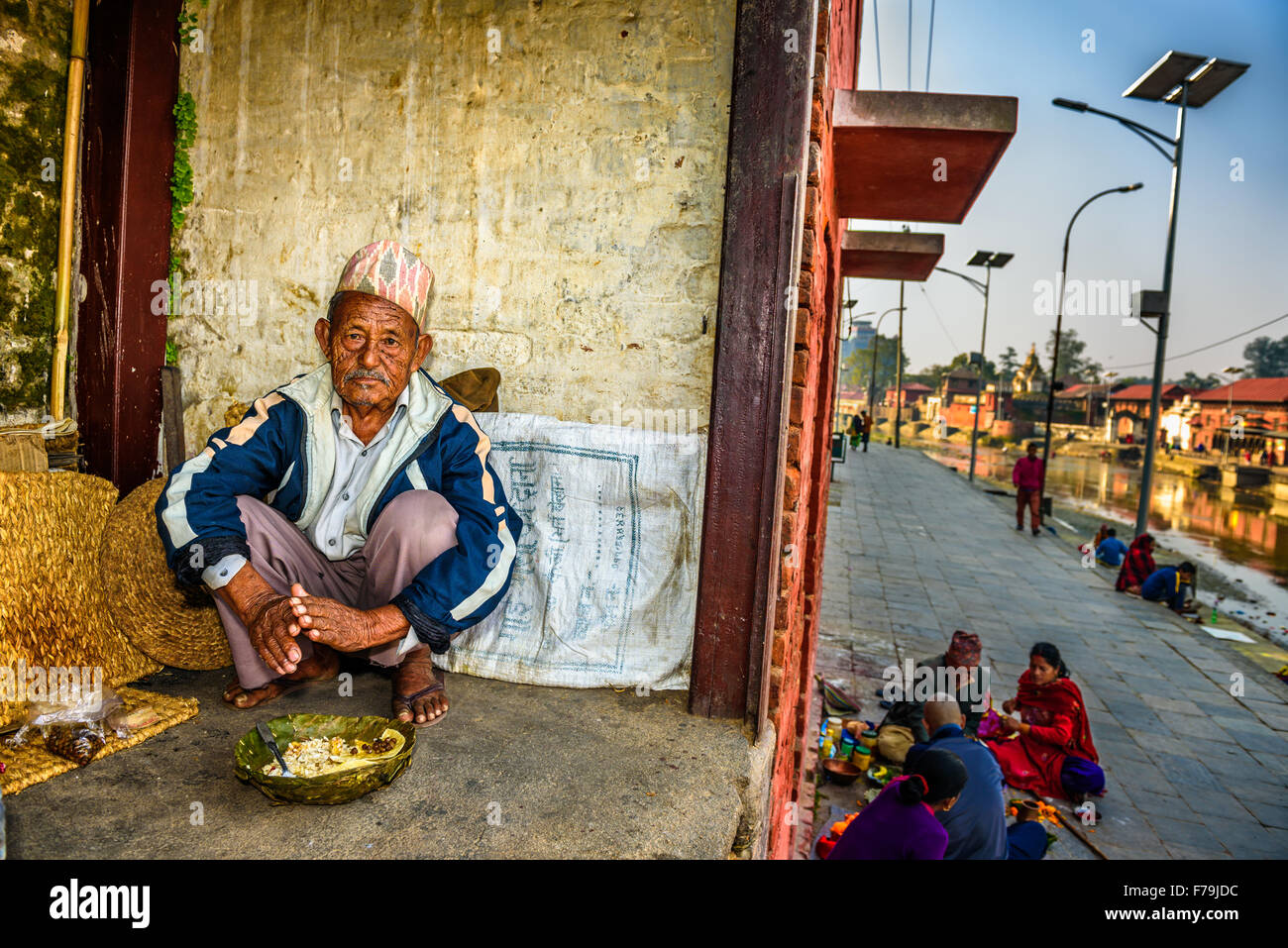 Elderly beggar eats in  ancient Pashupatinath Temple complex Stock Photo
