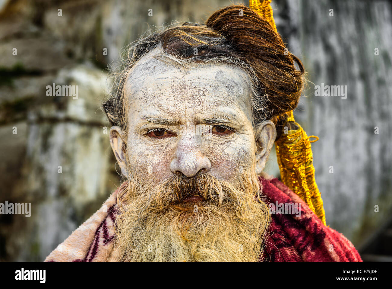 Portrait of wandering  Shaiva sadhu (holy man) with traditional face painting in ancient Pashupatinath Temple Stock Photo