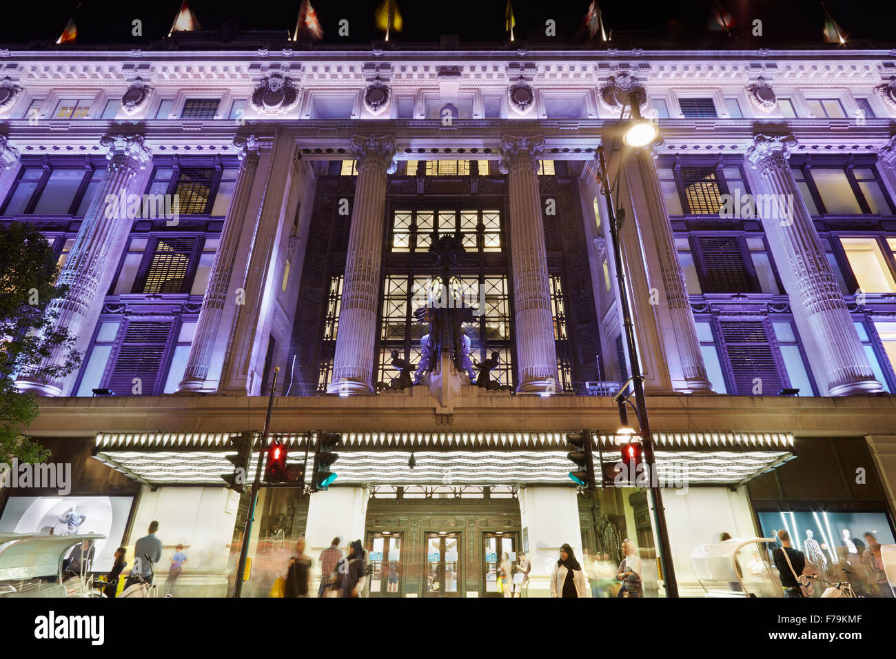 Selfridges Department Store facade in Oxford Street illuminated at night with people passing, central London Stock Photo